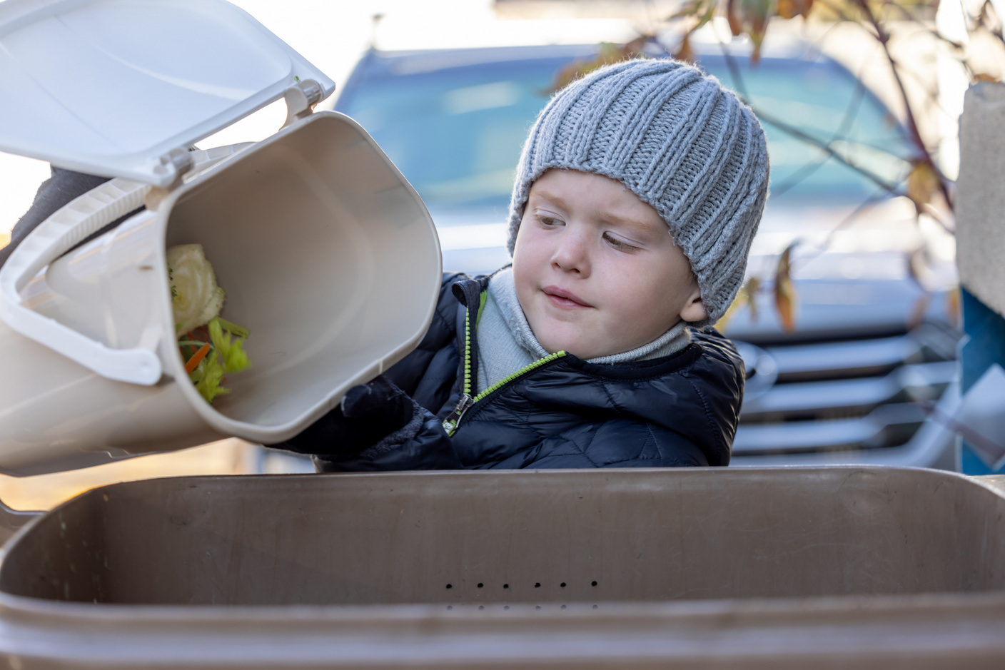 Little Boy Composting at Home and Emptying Food Waste in Composting Bin Little Boy Composting at Home and Emptying Food Waste in Composting Bin